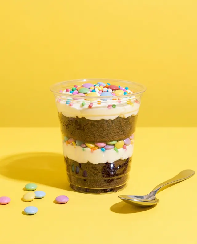 Bolo de pote com confeitos coloridos em fundo amarelo